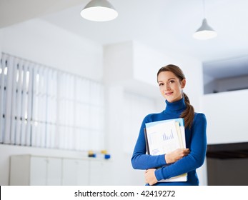 business woman holding reports and looking at camera. Copy space