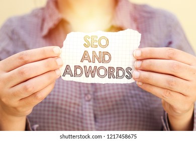 business woman holding tear paper with SEO AND ADWORDS text