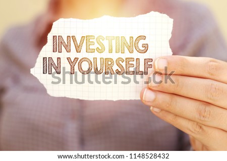 business woman holding tear paper with investing in yourself text