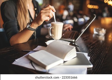 Business woman indoor with coffee and laptop taking notes - Powered by Shutterstock