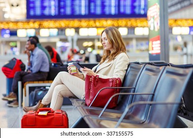 Business Woman At International Airport Reading Book And Drinking Coffee In Terminal. Angry Passenger Waiting. Canceled Flight Due To Pilot Strike.