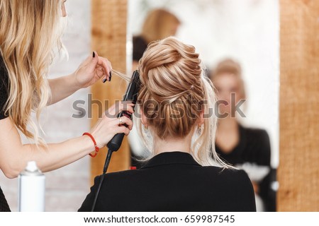 business woman lady boss in beauty salon making hairdress and looking to the mirror