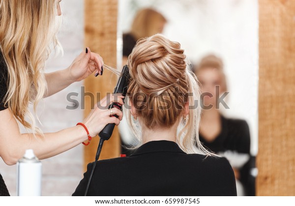 business woman lady boss in beauty salon making\
hairdress and looking to the\
mirror