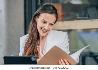 business woman with laptop on the terrace reviewing documents - Powered by Shutterstock