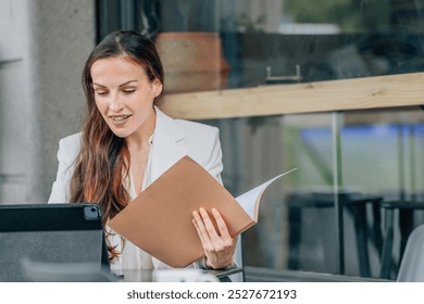 business woman with laptop on the terrace reviewing documents - Powered by Shutterstock