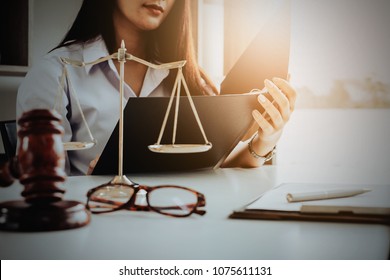Business woman and lawyers discussing contract papers with brass scale on wooden desk in office. Law, legal services, advice, Justice and real estate concept.