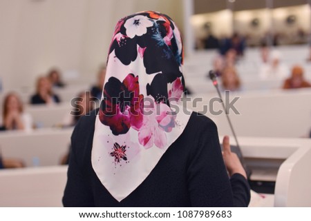 Business woman as leader speaking at Conference. Audience at the conference room or hall , representing model of economic development and startup business and interreligious relations