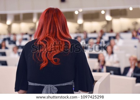 Business woman as leader speaking at Conference. Audience at the conference room or hall , representing model of economic development and startup business and interreligious relations