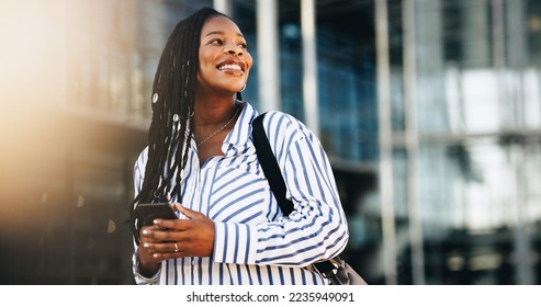 Business woman is looking away and smiling. She is standing in the city with a smartphone in her hand. Woman commutes to work in the morning. - Powered by Shutterstock