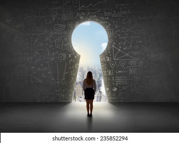 Business woman looking at keyhole with bright cityscape concept background - Shutterstock ID 235852294