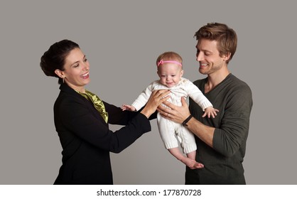 Business Woman And Mother Handing Child To Stay At Home Father 