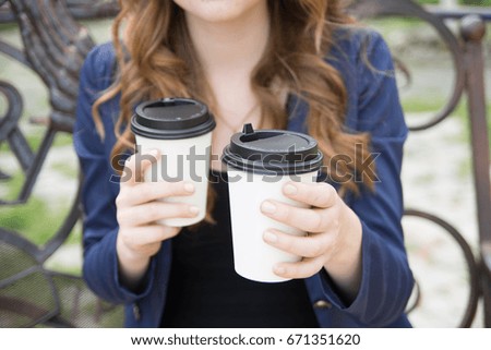 Business woman offers coffee on the bench