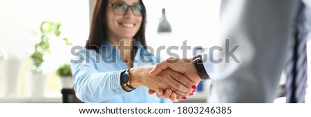 Business woman in office shakes hands with business partner. Mutually beneficial cooperation concept