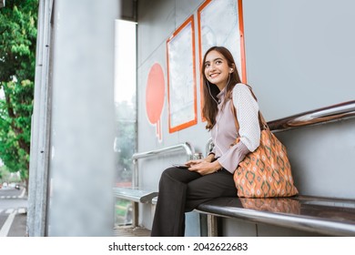 business woman on a bus station waiting for the bus to come - Powered by Shutterstock