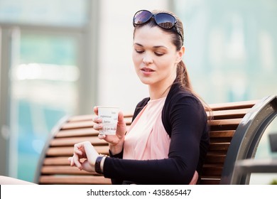 Business woman on coffee break, looking at the clock on the hand