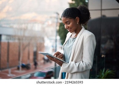 Business woman on a digital tablet outside a modern office alone. Smiling corporate worker looking at web and social media posts on a balcony. Female employee on a touchscreen device with copy space