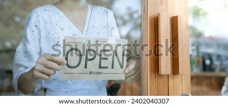 Business woman owner open on the first day of business. guarantees safety, cleanliness, open the coffee shop. open for New normal. Small business, welcome, restaurant, home made