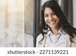 Business woman, portrait smile and window for corporate management, leadership or success at office. Happy and friendly young female leader or manager smiling for career goals, ambition or startup