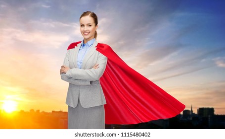 Business, Woman Power And People Concept - Smiling Businesswoman In Red Superhero Cape Over Sunset In City Background