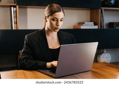 Business woman professional user using computer technology, doing online work in office or browsing the web, sitting in home office - Powered by Shutterstock