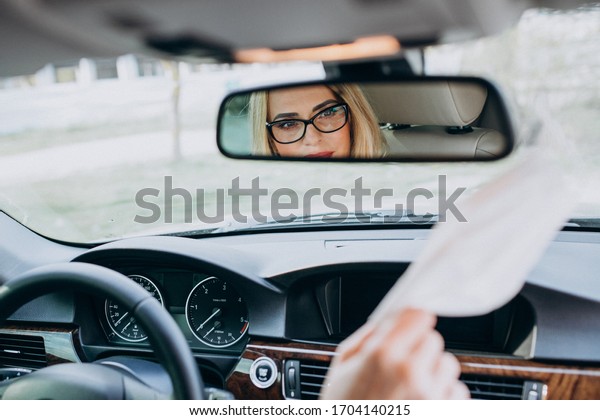 Business\
woman in protection mask sitting inside a\
car