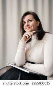 A business woman psychologist smiles using a laptop computer, in beige office clothes. Good mood during the day at work. - Shutterstock ID 2255005815