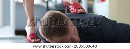 Business woman put heel on back of businessman closeup