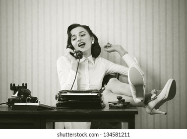 Business Woman Puts Her Feet Up On Her Desk On The Phone