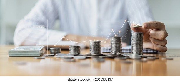 Business Woman putting a coin on a pile of coins. Placing coins in a row from low to high is comparable to saving money to grow more. The concept of growing savings and saving by investing in a stock.