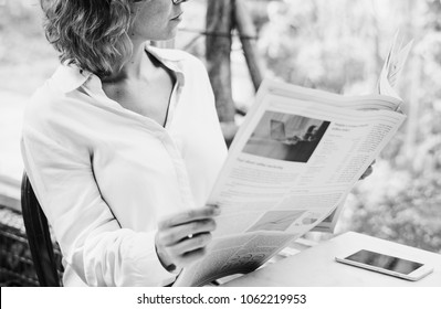 Business woman reading newspaper in the morning - Powered by Shutterstock