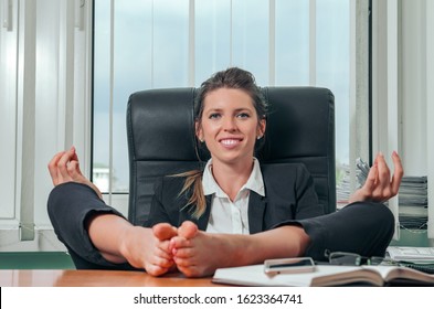 Business Woman Relaxing With Her Feet On The Desk In Office