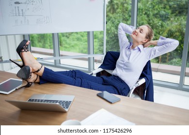 business woman relaxing or sleeping with her feet on the desk in office. female boss worker close eyes sitting with legs on the table in the resting time at work place 