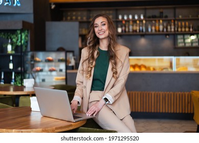 Business Woman Restaurant Owner Use Laptop In Hands Dressed Elegant Pantsuit Sitting On Table In Restaurant With Bar Counter Background Caucasian Female Business Person Indoor