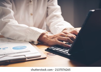 Business Woman Reviewing Data In Financial Charts And Graphs On Wooden Desk In Office And Business Working, Tax, Accounting, Statistics And Analytic Research Concept