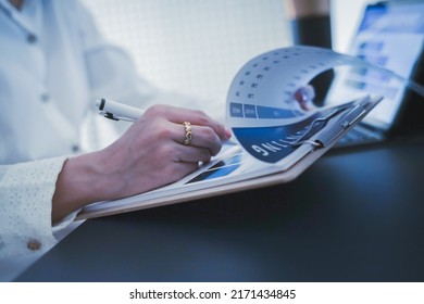 Business Woman Reviewing Data In Financial Charts And Graphs On Wooden Desk In Office And Business Working, Tax, Accounting, Statistics And Analytic Research Concept