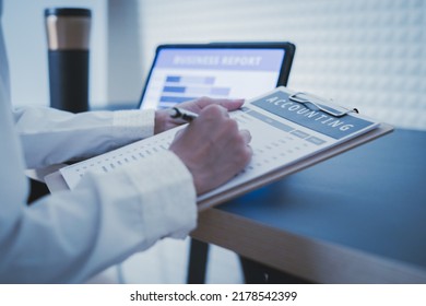 Business Woman Reviewing Data In Financial Charts And Graphs On Wooden Desk In Office And Business Working, Tax, Accounting, Statistics And Analytic Research Concept