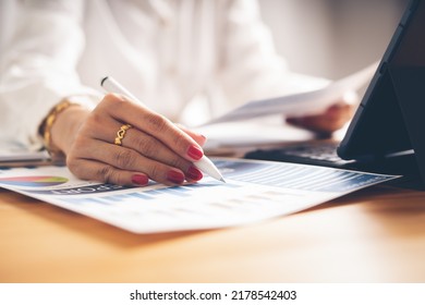 Business Woman Reviewing Data In Financial Charts And Graphs On Wooden Desk In Office And Business Working, Tax, Accounting, Statistics And Analytic Research Concept