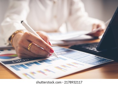 Business Woman Reviewing Data In Financial Charts And Graphs On Wooden Desk In Office And Business Working, Tax, Accounting, Statistics And Analytic Research Concept