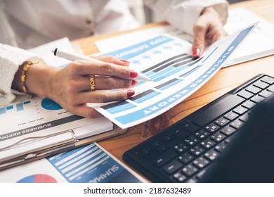 Business Woman Reviewing Data In Financial Charts And Graphs On Wooden Desk In Office And Business Working, Tax, Accounting, Statistics And Analytic Research Concept