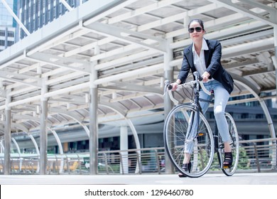 Business woman riding bicycle to work on urban street in city .transport and healthy . fashion lifestyle cool smart.