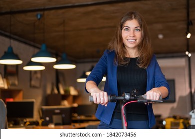 Business Woman Riding An Electric Scooter In The Office