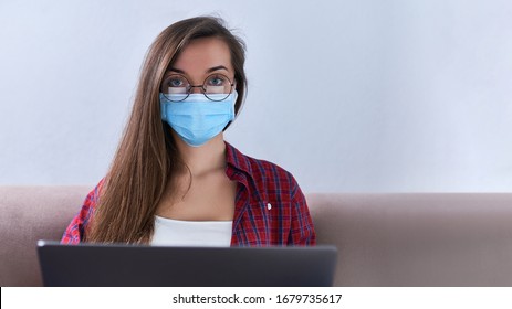 Business Woman In Round Glasses Wears Medical Protective Mask Working From Home At The Computer During Self-isolation And Quarantine. Coronavirus Outbreak And Covid Epidemic. Stay Home. Copy Space