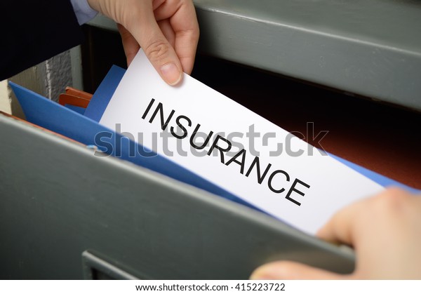 Business woman seeking an insurance policy in a\
filing cabinet