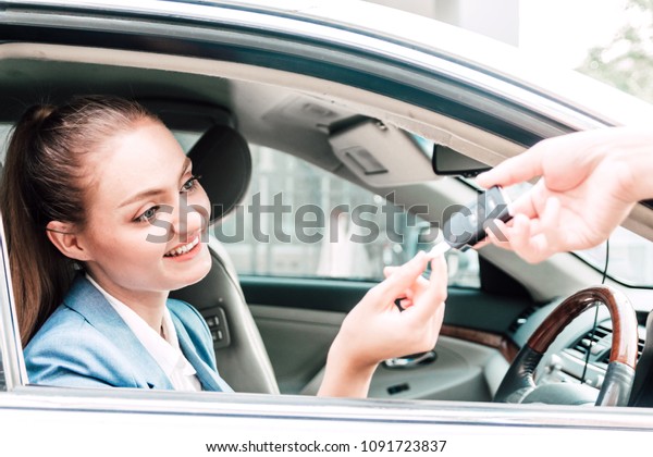Business\
woman showing car keys while sitting in\
car
