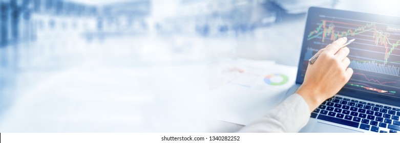 Business woman shows at graph on laptop or notebook. Computer screen with graphics of cryptocurrency chart. Wide banner or panorama technology concept.