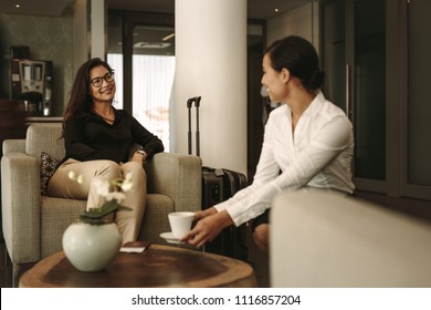 Business Woman Sitting At Airport Lounge With Waitress Serving Coffee. Business Traveler Waiting For Flight At Airport Lounge.