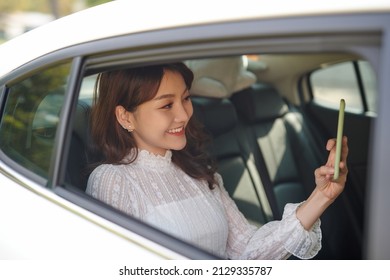 Business Woman Sitting On Back Seat In Taxi Car, Taking Selfie.