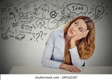 Business woman sitting at table has many ideas things to do planning future isolated grey office wall background. Perception of career. Personal life work balance concept. Decision making process
