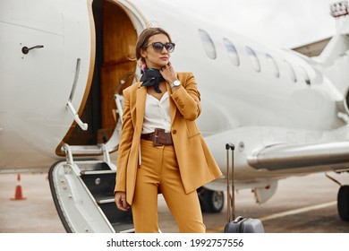 Business woman stand near private airplane jet