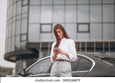 Business Woman Standing By The Car And Using Phone